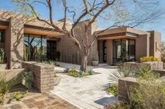 the front entrance to a modern home surrounded by desert landscaping