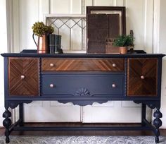 an old dresser is painted blue and has some plants on top, along with a mirror