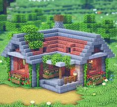 a small brick house in the middle of a green field with trees and flowers on it