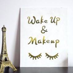 the eiffel tower is next to a sign that says wake up and makeup