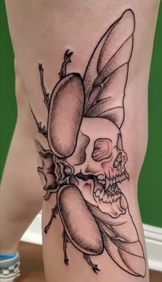 a person with a tattoo on their leg and a skull in the middle of it