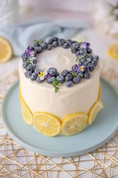 a cake decorated with blueberries and lemon slices