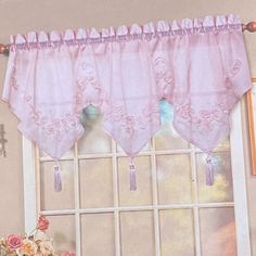 the window is decorated with pink curtains and flowers