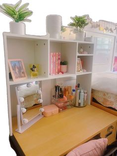 a wooden desk topped with a white shelf filled with lots of different types of items