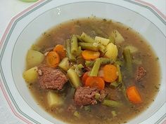 a white bowl filled with meat and vegetables