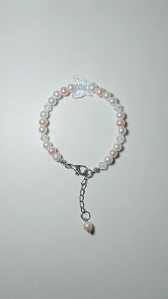 a bracelet with pearls and a butterfly charm