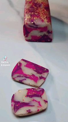 three different types of soaps sitting on a table next to each other with pink and white designs