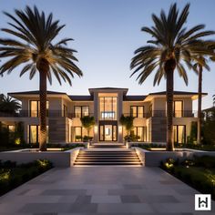 a large house with palm trees in the front yard at night time, and steps leading up to it