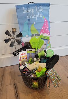 a basket filled with assorted items sitting on top of a wooden floor next to a sign