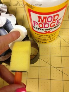 a hand holding a sponge next to a container of pop - up popsicles