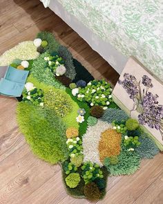 a green rug on the floor next to a bed with white and purple flowers in it