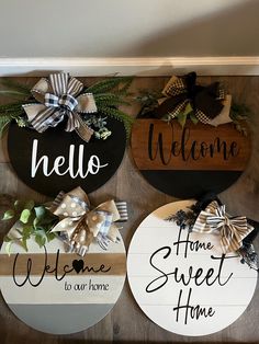 three wooden signs are hanging on the wall next to each other with bows and welcome home written on them