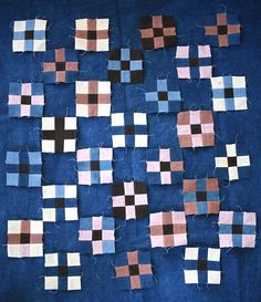 several pieces of cloth are arranged on a blue surface, with squares and rectangles in different colors