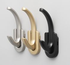 three black and gold door handles on a white wall