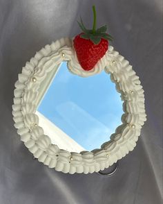 a mirror with a strawberry on top of it