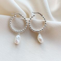 ✤latch style hoops ✤available hoop sizes: 14.6mm and 25.8mm ✤pearl charms: 10-15mm ✤all hardware is 925 sterling silver These biwa pearl hoops are bold, minimal and just perfect!  Sure to become a new staple in your collection and durable for everyday wear :) The sterling silver hoop earrings are crafted with bead wire to create the look of a strand of round beads which catch and reflect the light beautifully.  The baroque freshwater pearls are unique and have a high luster.  The hinged posts cl Sterling Silver Hoop Pearl Earrings, Nickel Free Silver Hoop Pearl Earrings, Nickel-free Silver Hoop Pearl Earrings, Handmade Silver Hoop Pearl Earrings, Silver Pearl Hoop Earrings For Pierced Ears, Silver Hoop Pearl Earrings, Pearl Jewelry Silver, Hoop Pearl Earrings, Bali Wedding