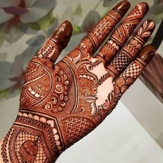 the hand is decorated with henna designs on it's fingers and palmes