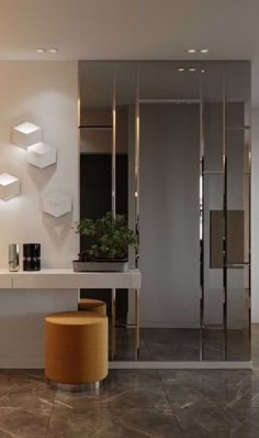 a modern bathroom with marble flooring and white walls, along with mirrors on the wall