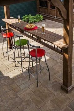 an outdoor table with four chairs and a plate of food on it, in the middle of a patio