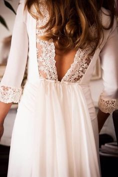 the back of a woman's white dress with lace detailing