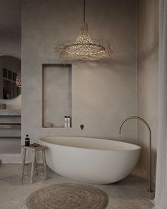 a large white bath tub sitting next to a sink in a bathroom under a chandelier