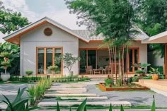 a house that is in the middle of some trees and grass with steps leading up to it