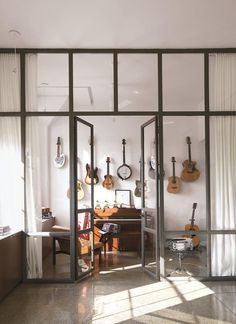 an open room with guitars hanging on the wall and a rug in front of it