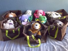 several stuffed animals are sitting in bags on a bed