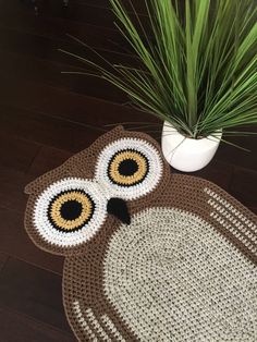 an owl rug on the floor next to a potted plant