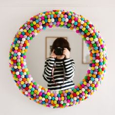 a person taking a photo in a mirror with candy bead wreaths on it