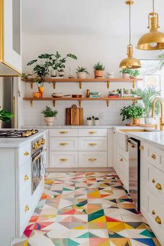 a kitchen with white cabinets and colorful floor tiles on the walls, potted plants above the stove