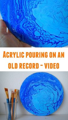 a blue bowl sitting on top of a table next to paint brushes and pencils