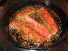 two pieces of meat cooking in a frying pan