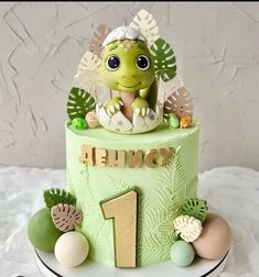 a green cake decorated with an image of a baby turtle on it's top