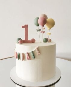 a birthday cake decorated with balloons and streamers