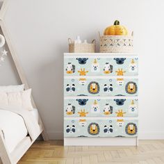 a blue and yellow patterned dresser next to a white bed in a child's room