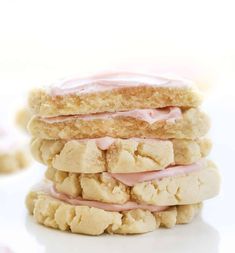 three cookies with pink icing stacked on top of each other