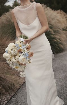 a woman in a wedding dress holding a bouquet