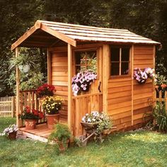 a small wooden shed with flowers in the window