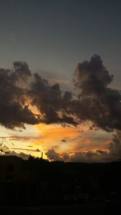 the sun is setting behind some clouds in the sky