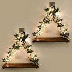 two wooden shelves with lights on them in the shape of triangle shaped branches and flowers