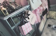 a pink and white purse sitting on top of a table next to a chair with a cell phone