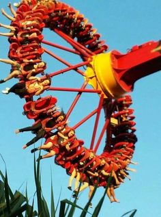 a ferris wheel with lots of people on it's sides and some trees in the background