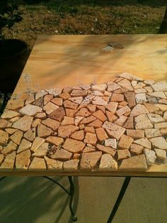 a wooden table topped with lots of small rocks on top of it's sides