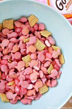 a blue bowl filled with pink and yellow cheetos next to a can of cereal