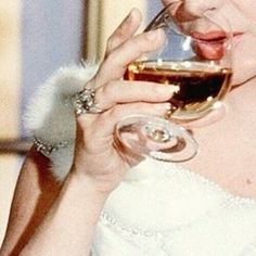 a woman in a white dress holding a glass of wine