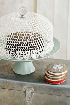 a cake on top of a metal tray next to some plates and a cupcake