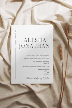 an image of a wedding card on top of a bed with white sheets and flowers