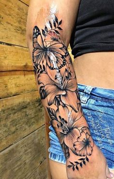 a woman's arm with flowers and butterflies on it