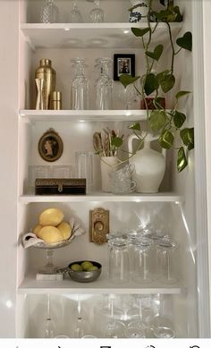 a white shelf filled with glasses and other items